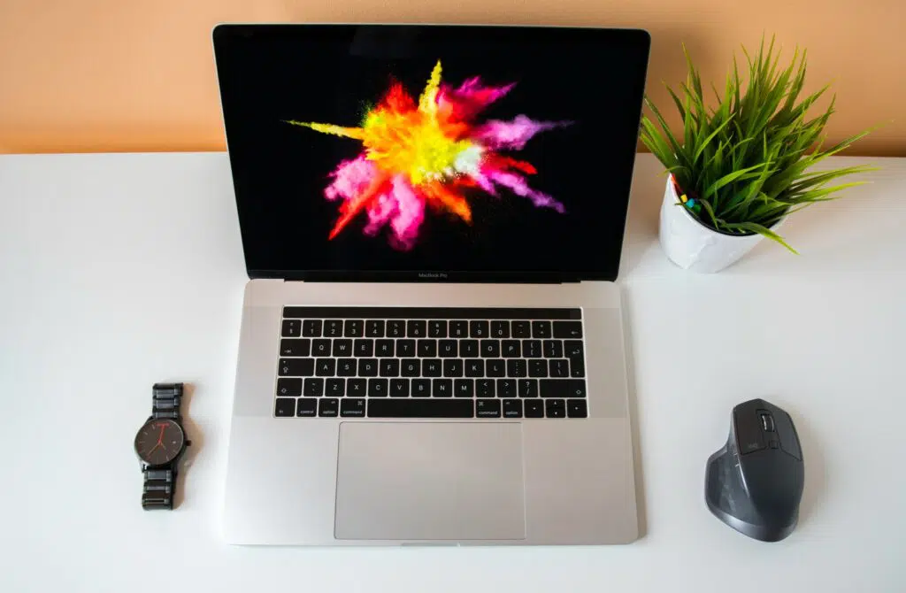flat lay photography of MacBook Pro in between mouse and watch