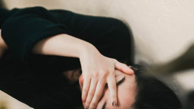 woman in black long sleeve shirt covering her face